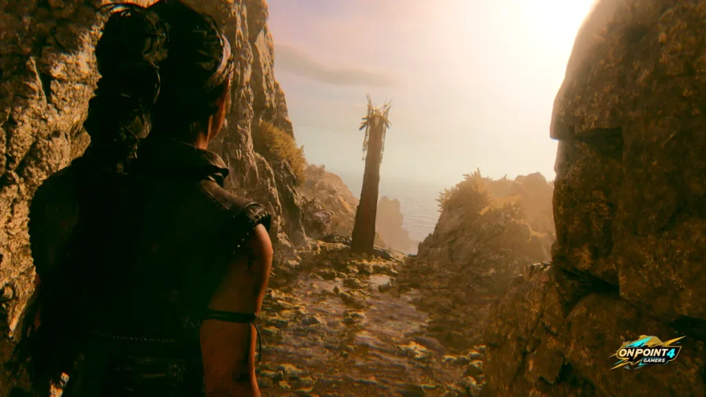 Senua looks out over a sunlit rocky mountain pass in Senua's Saga: Hellblade II